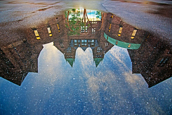 Photo of main building reflecting in a puddle by Scott Balzer