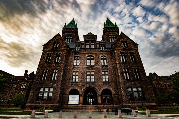 Photo of the exterior of the main building against a cloudy sky